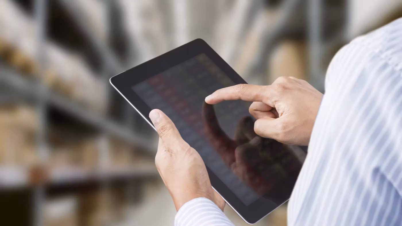 A hand working on a tablet held at chest height