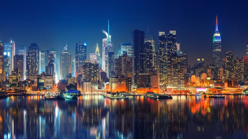 The Manhattan skyline at night seen across the Hudson River from the New Jersey side