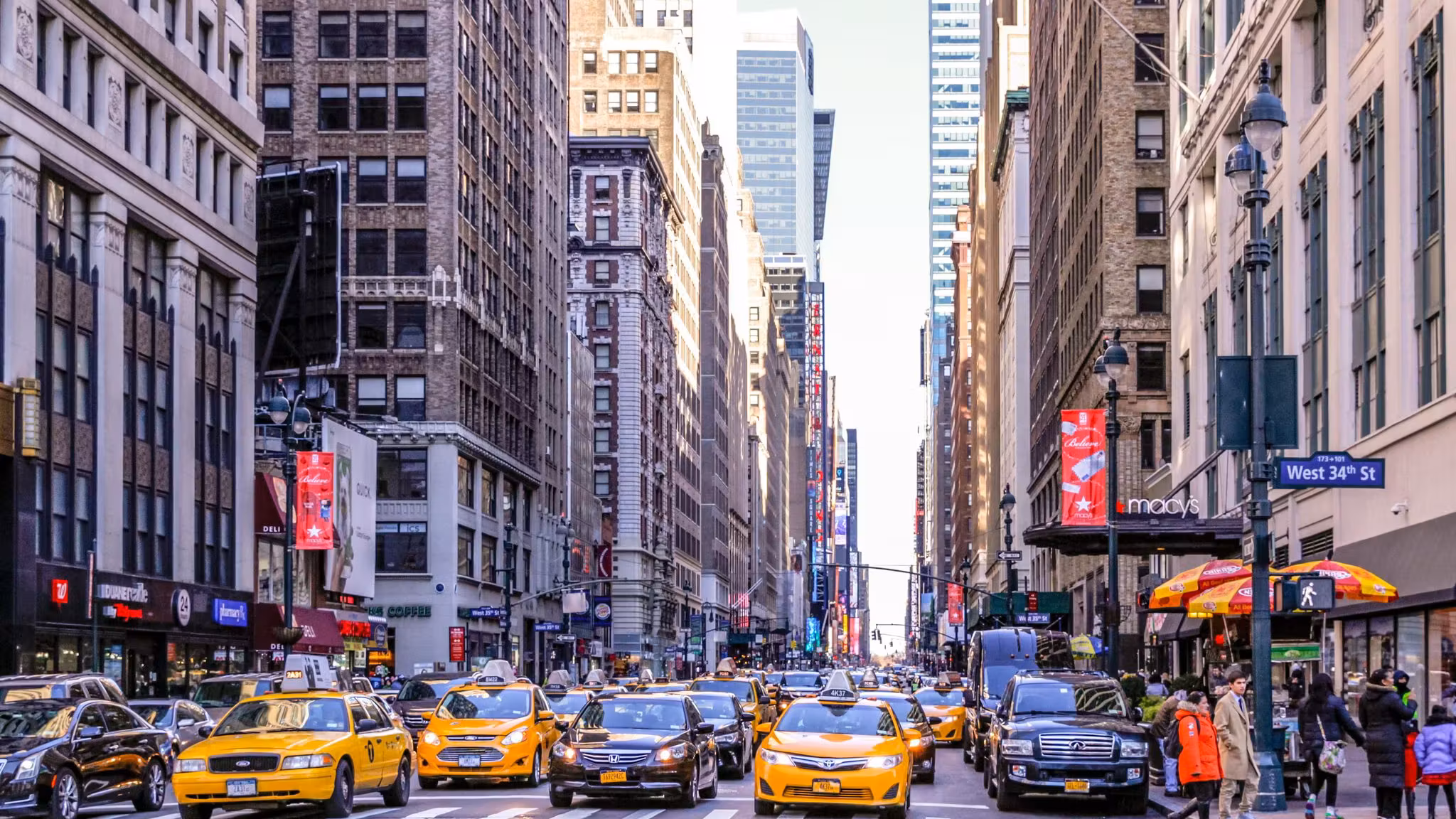 Yellow cabs filling a Manhattan avenue at street level near West 34th Street