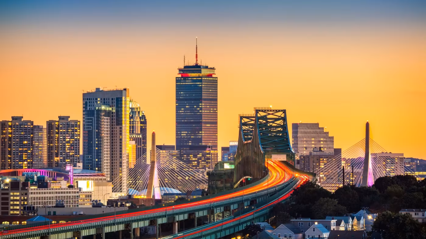 The Boston skyline at sunset above the elevated highway and the bridge