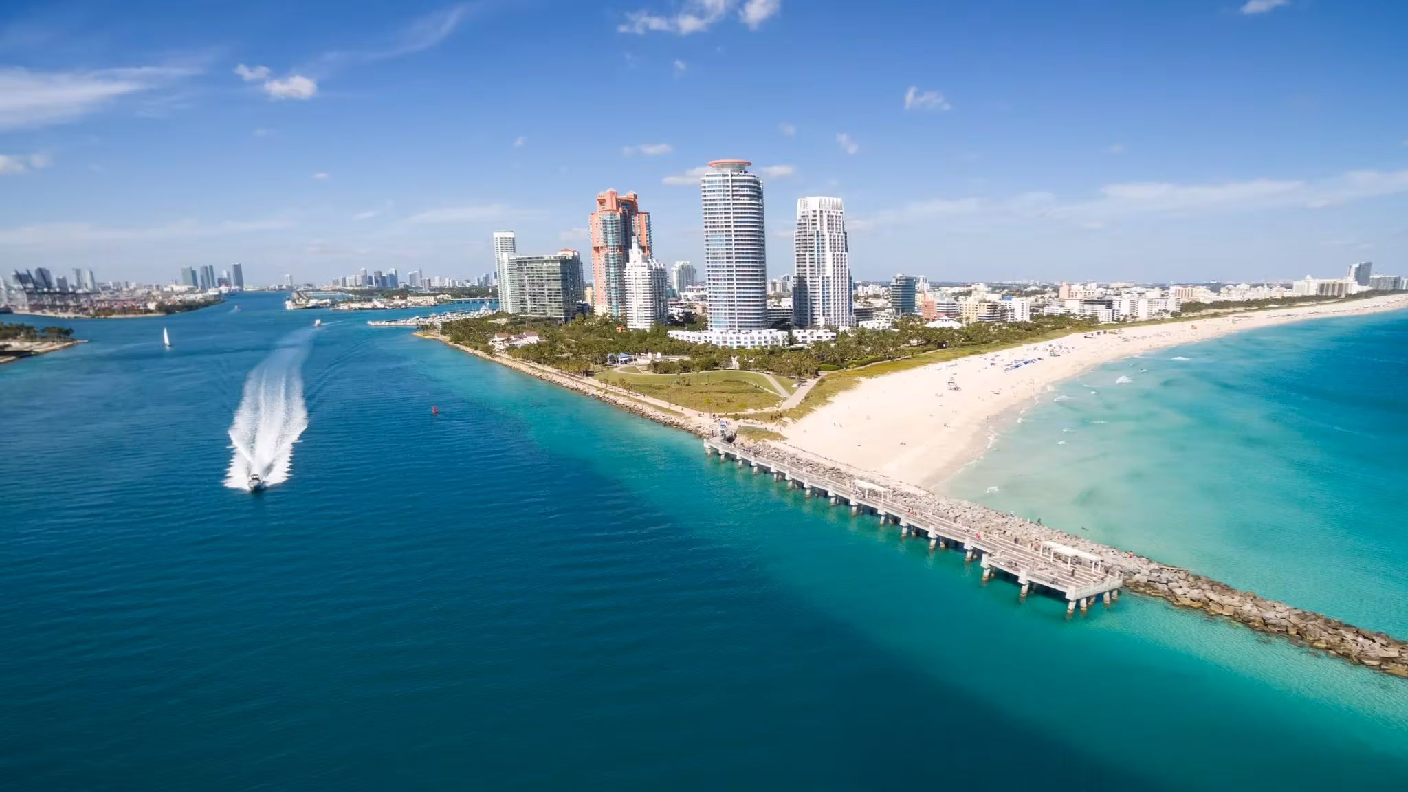 Aerial view of the beach at Miami's southern tip with a boat leaving the channel