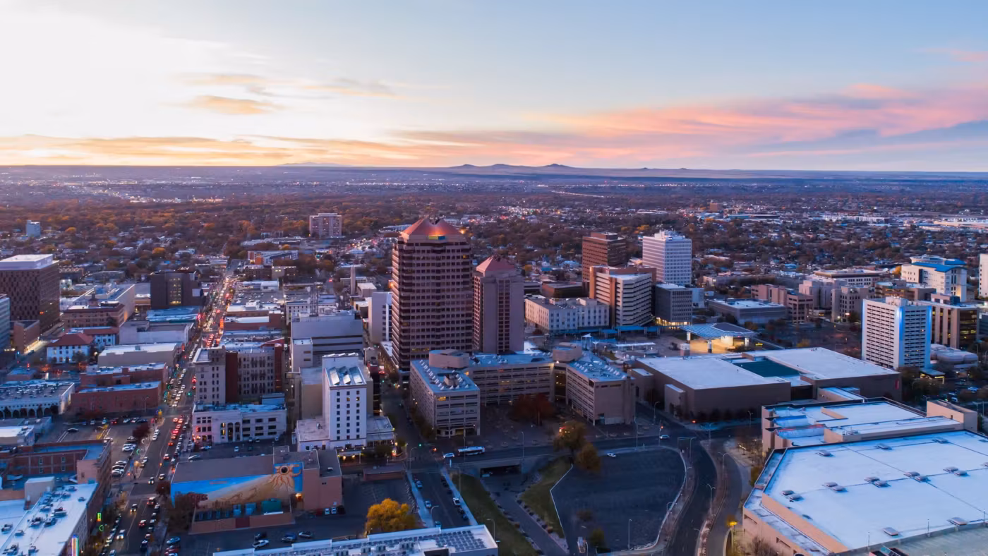 A New Mexico downtown from above at dusk with the plain stretching beyond