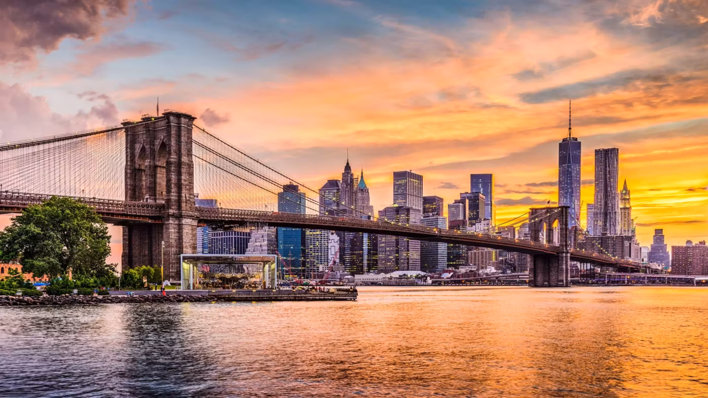 The Brooklyn Bridge at sunset with the Lower Manhattan skyline behind it