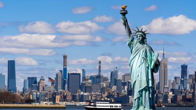 The Statue of Liberty with the Manhattan skyline across the harbour
