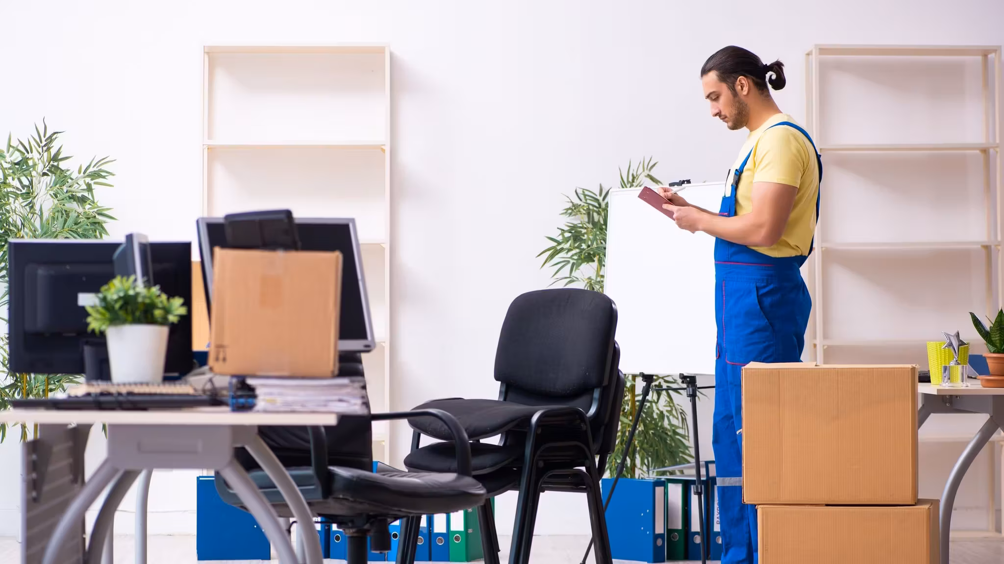 A mover taking notes on a tablet in a room being cleared