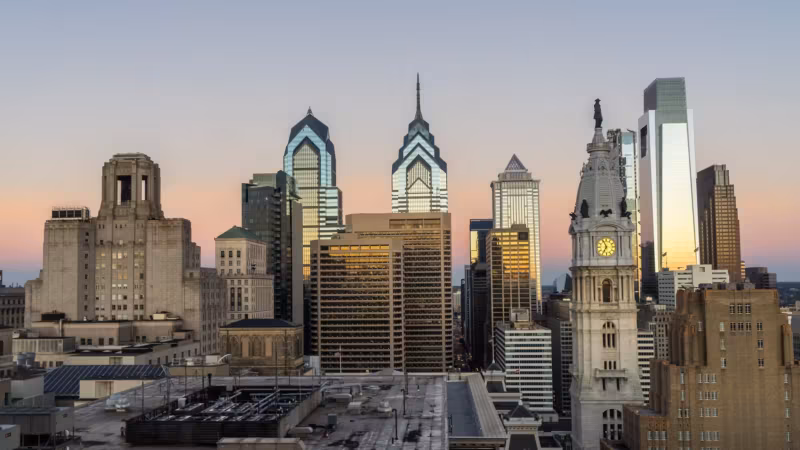 Philadelphia City Hall tower among the surrounding office buildings, seen from a rooftop