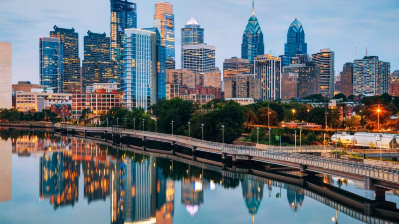 The Philadelphia skyline reflected in the Schuylkill River beside the expressway