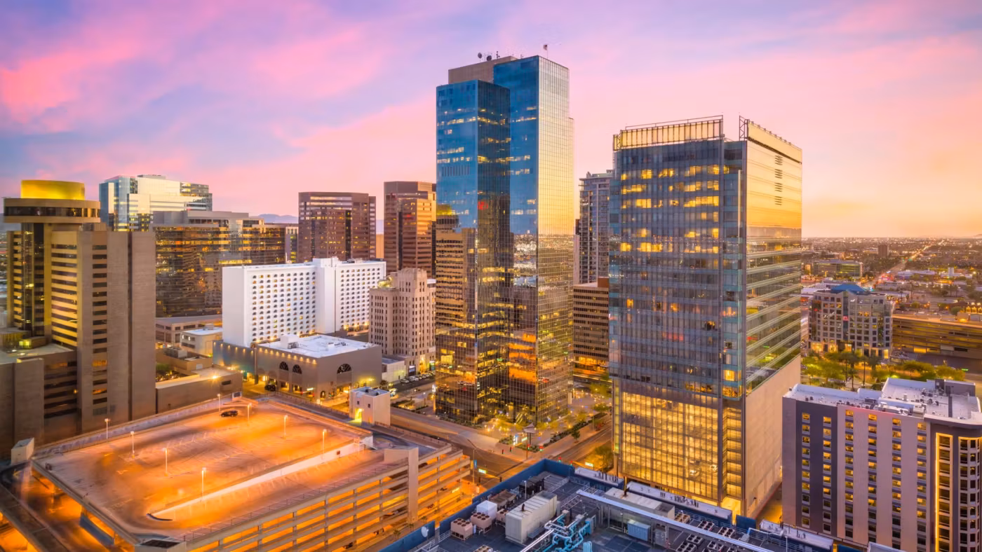 Downtown Phoenix from above at dusk, the streets lit below the towers