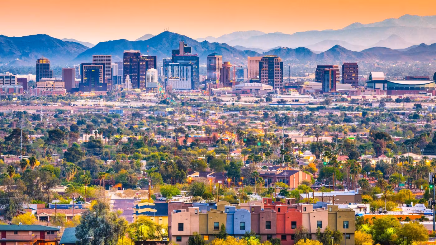 Downtown Phoenix with tile-roofed homes in front and the mountains behind