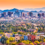 Downtown Phoenix with tile-roofed homes in front and the mountains behind