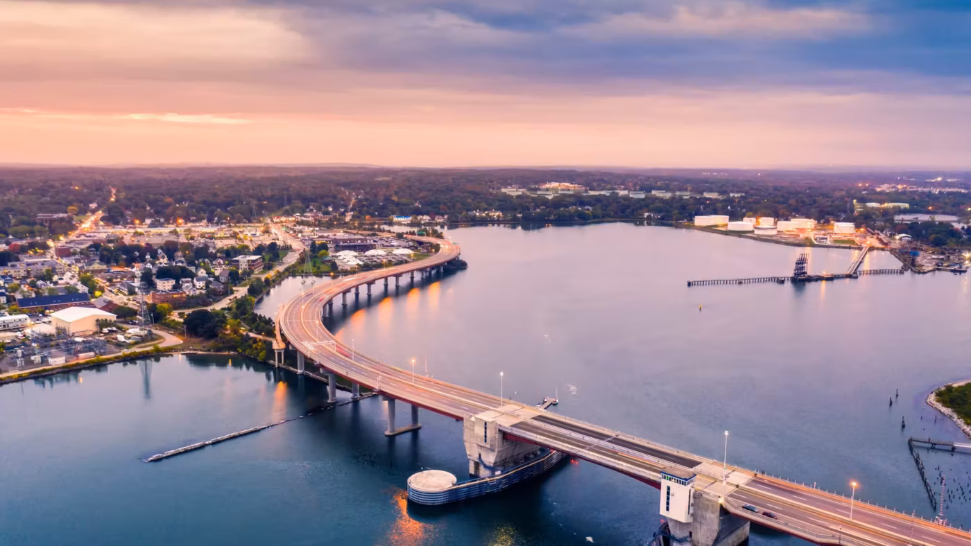 A bridge crossing the river at Portland with the far shore lit at dusk