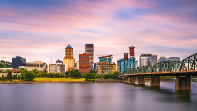 The Portland skyline across the Willamette River with the Hawthorne Bridge at dusk