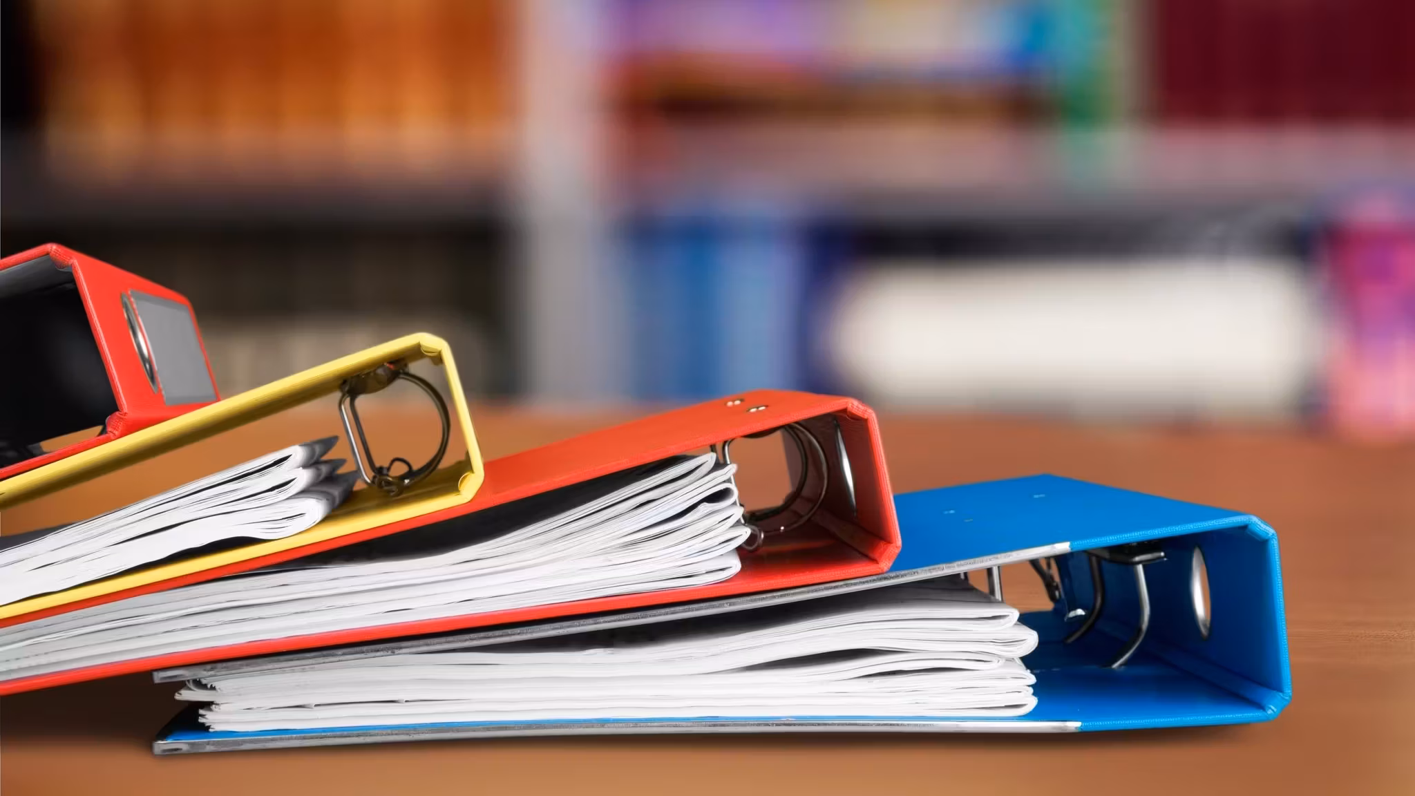Stacked ring binders with papers showing at the edges