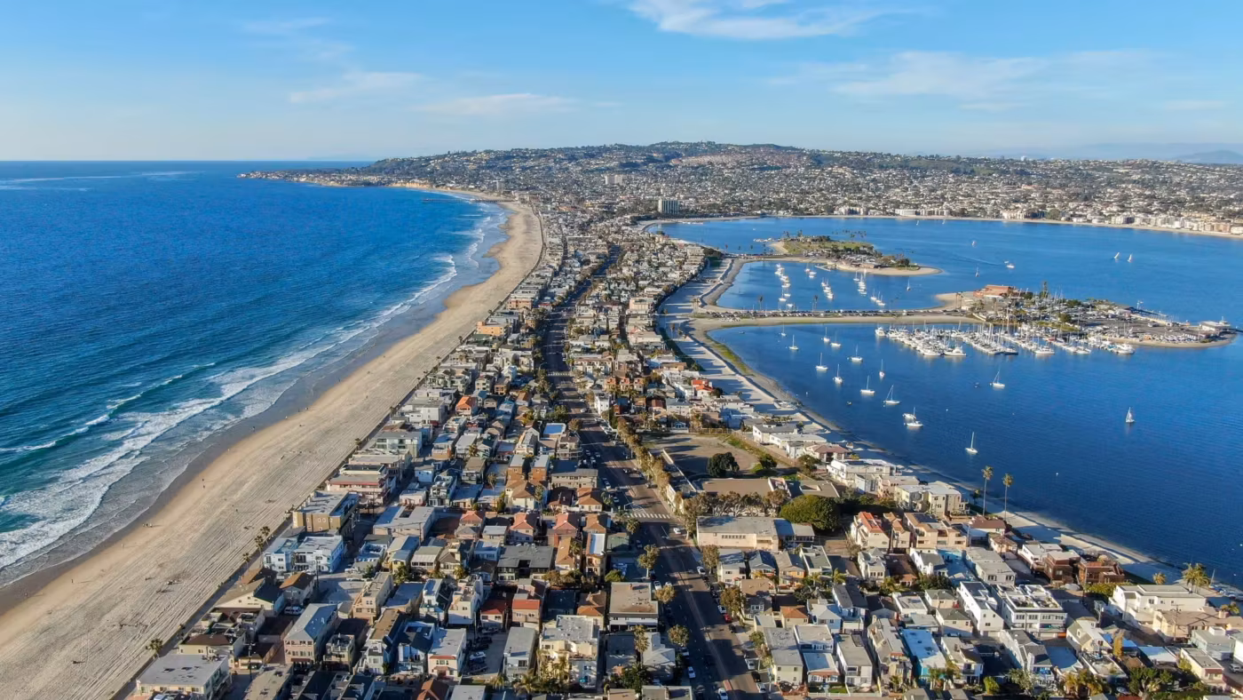 Aerial view of densely packed houses on the Mission Beach peninsula between the ocean and the bay in San Diego
