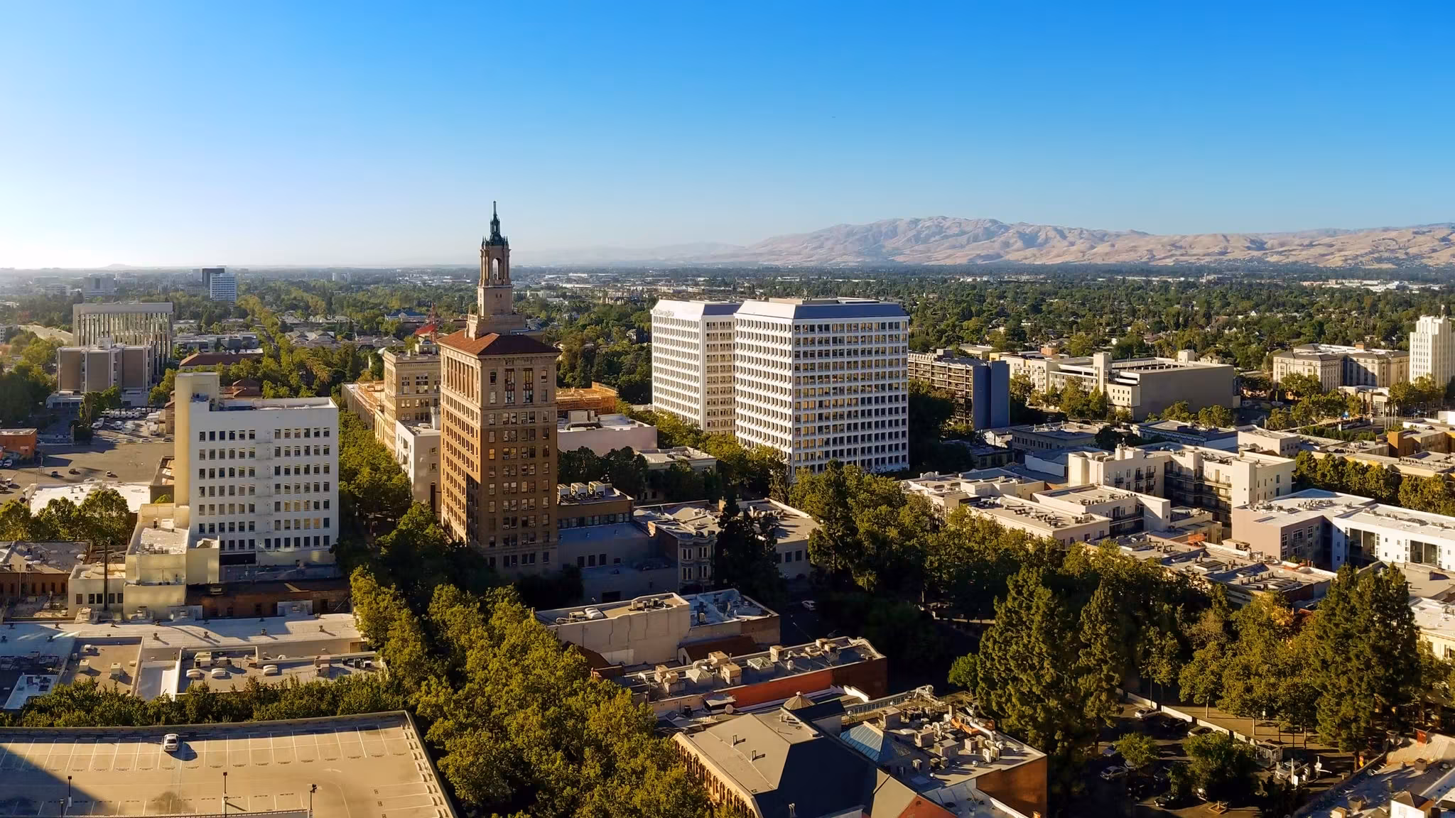 Downtown San Jose in daylight with the Bank of Italy tower rising above the trees