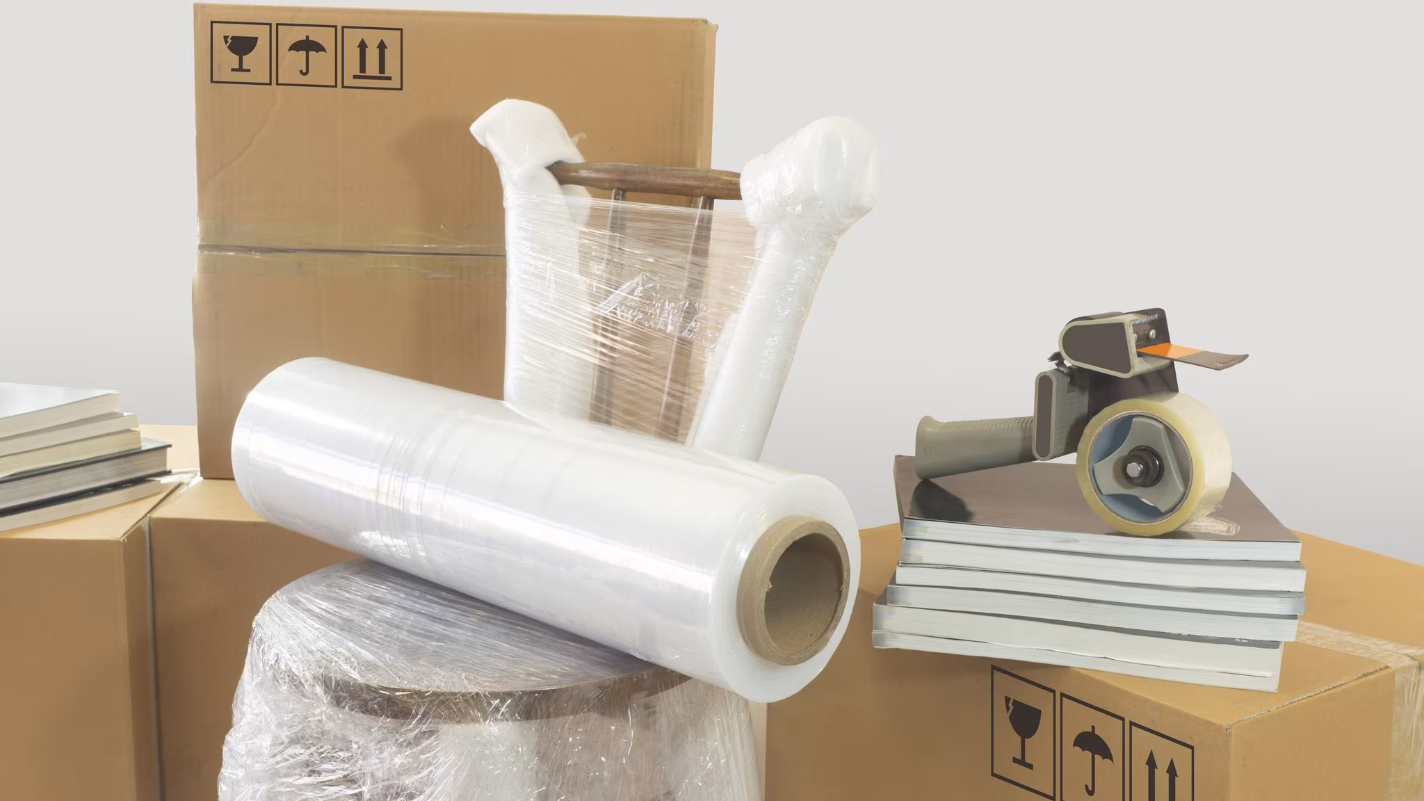 Rolls of stretch film standing beside sealed cartons