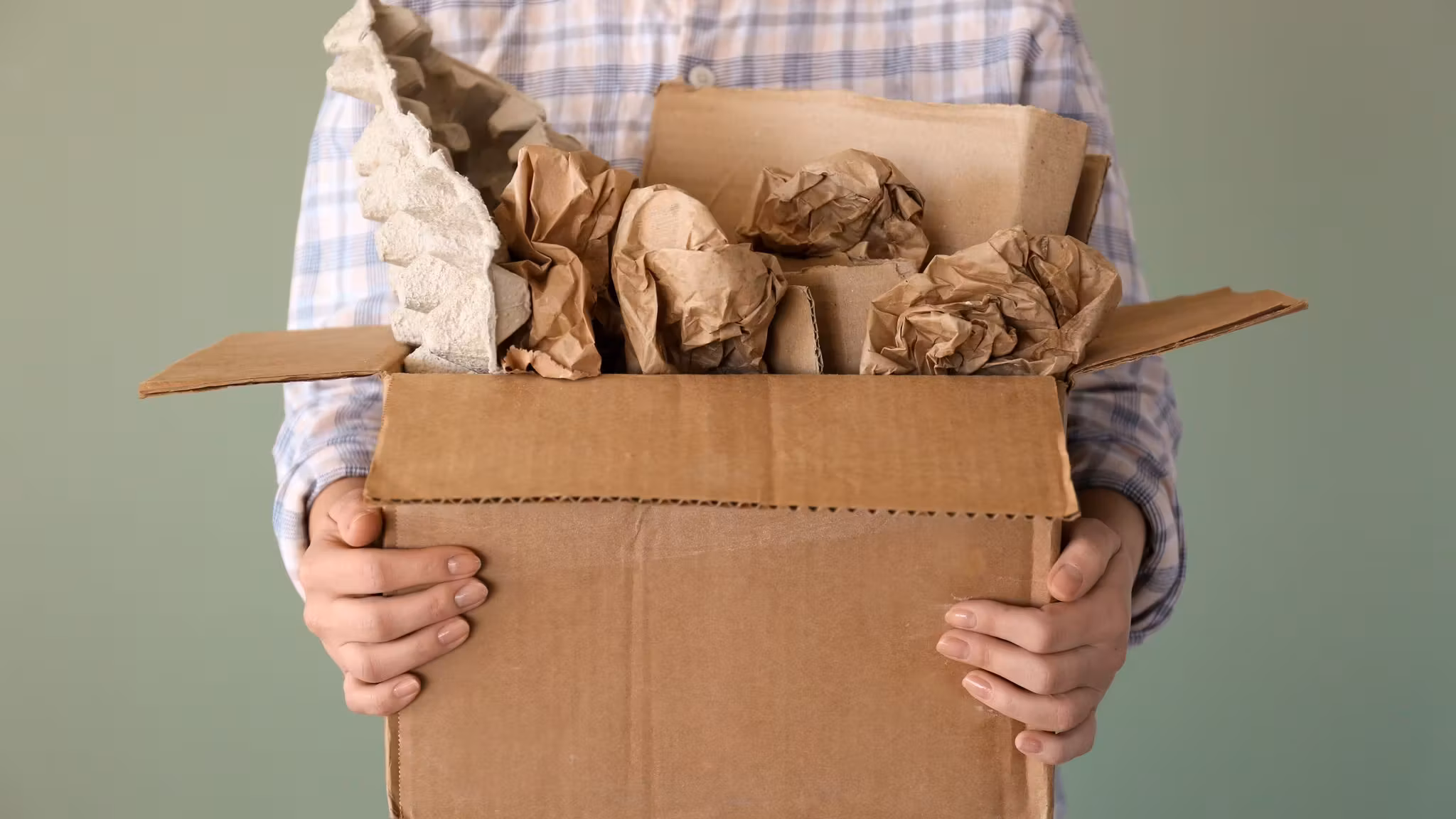 A carton held open, its contents each wrapped in packing paper