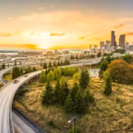 A freeway curving toward the downtown Seattle skyline at sunrise