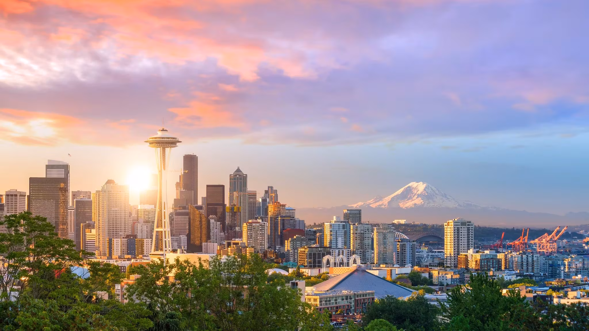 The Space Needle and downtown Seattle at sunset with Mount Rainier behind