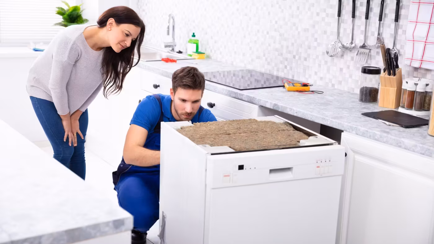 A mover crouched at an appliance while a resident looks on