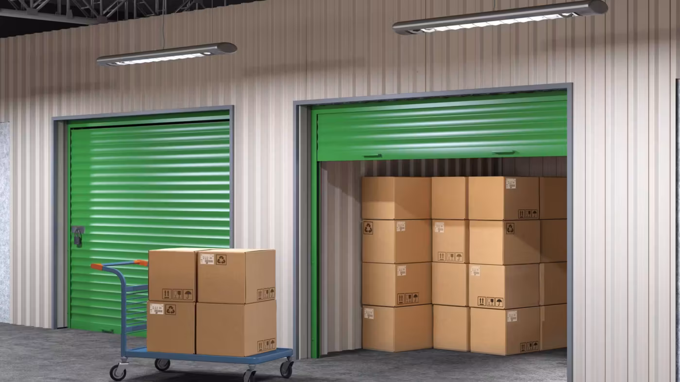 An open unit with cartons stacked square inside it and a flatbed trolley at the threshold