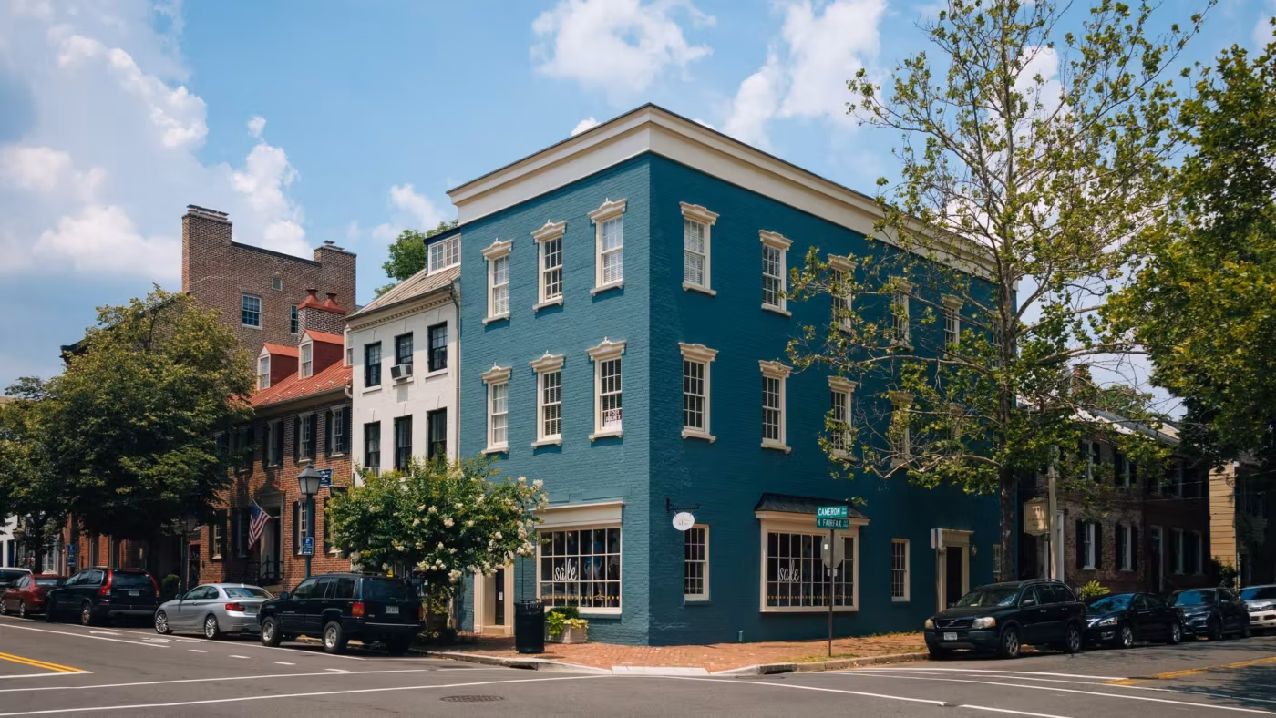 A teal-painted corner building and brick shopfronts on an old Virginia street