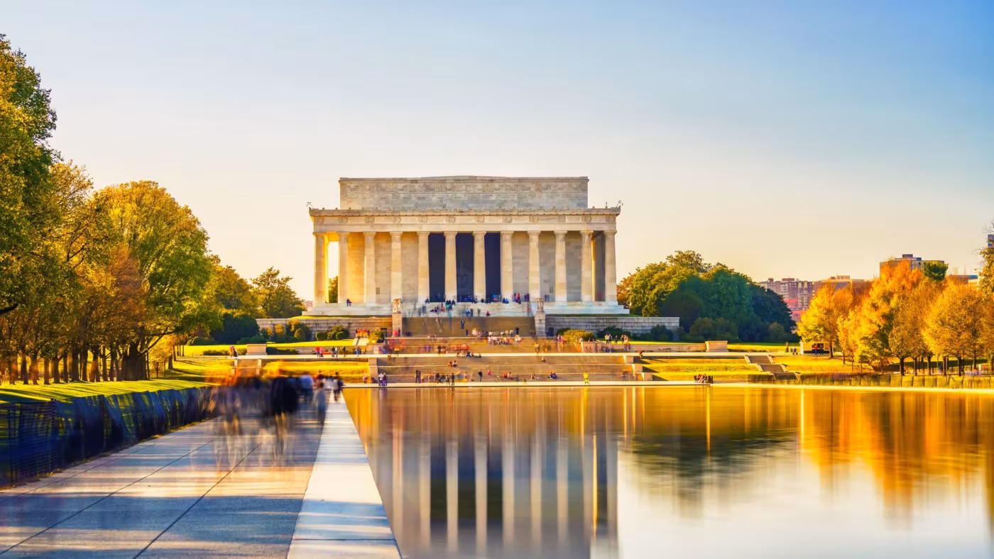 The Lincoln Memorial reflected in the pool with autumn trees along the banks