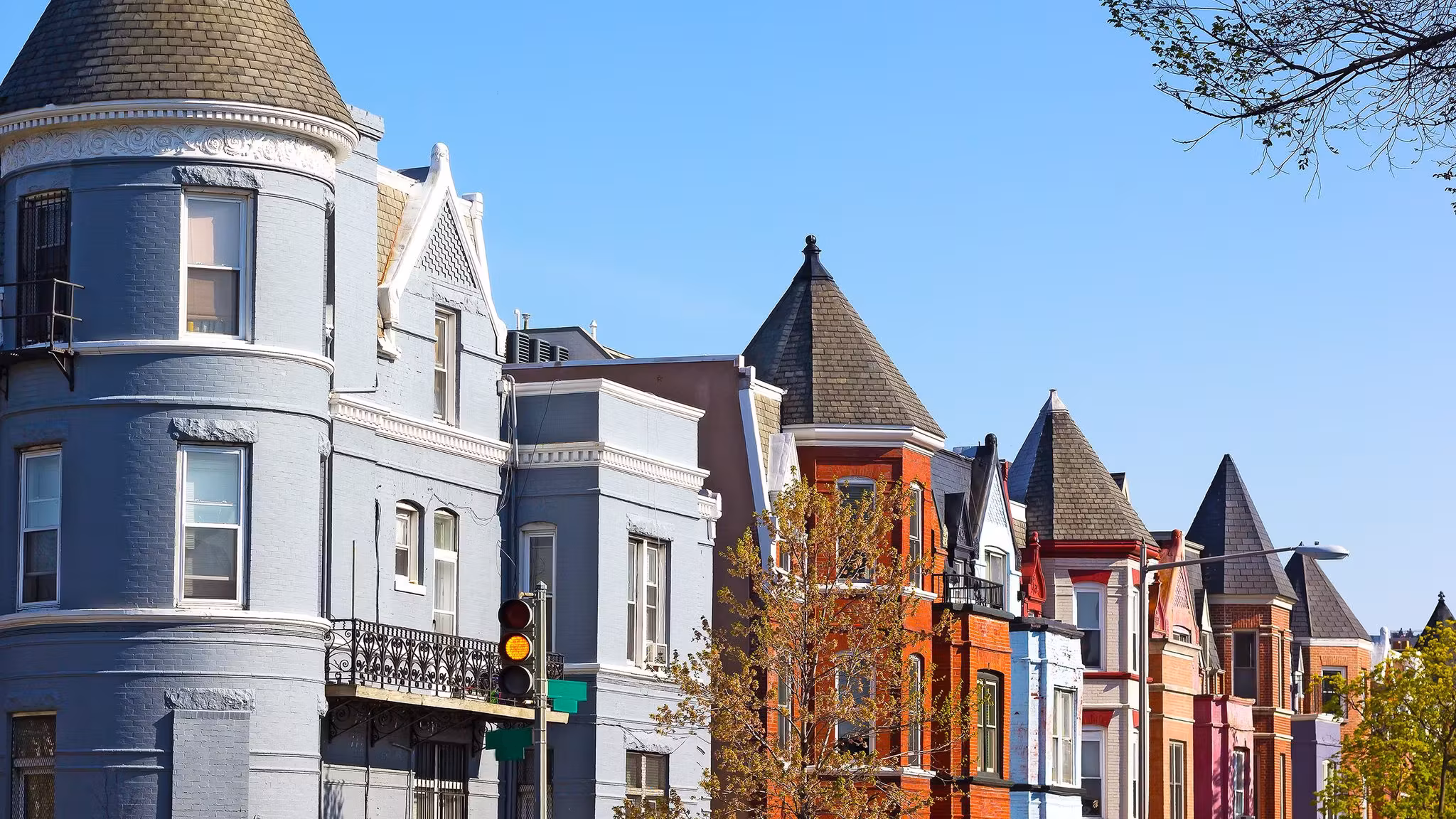 A row of turreted Washington DC rowhouses painted in different colors